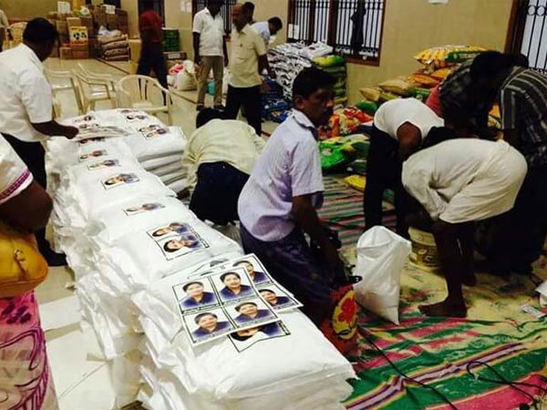 ADMK workers busy with sticking Amma stickers in Flood relief materials ADMK workers busy with sticking Amma stickers in Flood relief materials