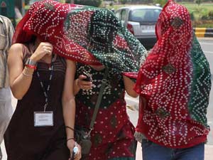 Girls cover themselves to get respite from the scorching heat during a hot day Girls cover themselves to get respite from the scorching heat during a hot day