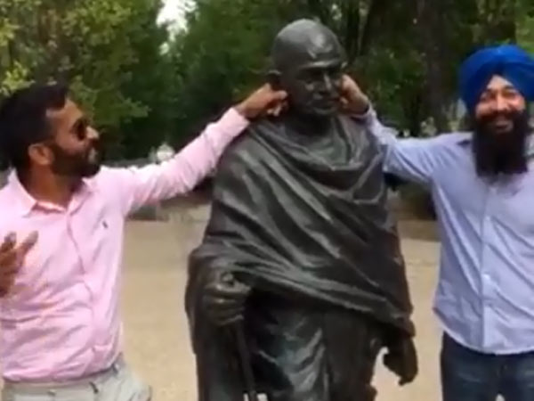 Two Indians defame Gandhi statue Two Indians defame Gandhi statue