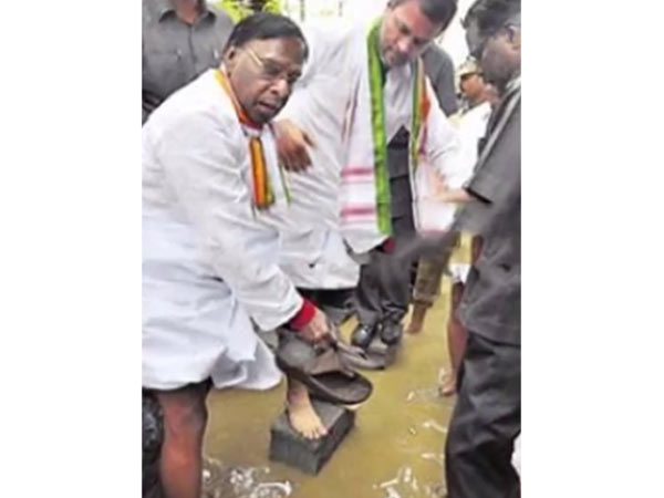 Former Minister V Narayanasamy holds slippers for Rahul Gandhi Former Minister V Narayanasamy holds slippers for Rahul Gandhi