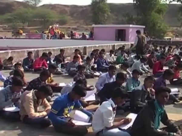 Students write exam on terrace as the dancers perform in school ground Students write exam on terrace as the dancers perform in school ground