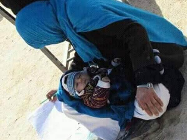 afghan woman writes exam while nursing her baby afghan woman writes exam while nursing her baby
