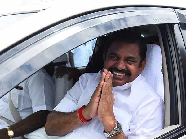 காரில் செல்கிறார்