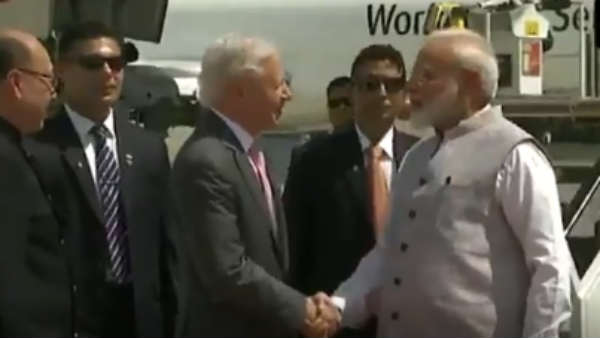 PM Narendra Modi picks flower which fell from bouquet at Houston Airport PM Narendra Modi picks flower which fell from bouquet at Houston Airport