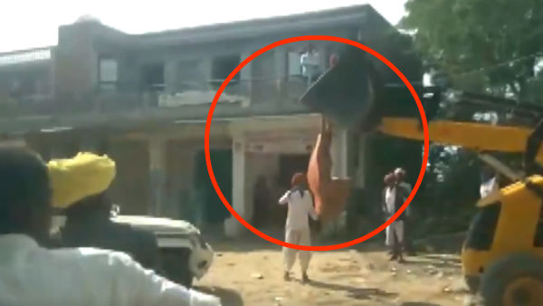 woman protest and tries to climb a jcb machine in gujarat woman protest and tries to climb a jcb machine in gujarat