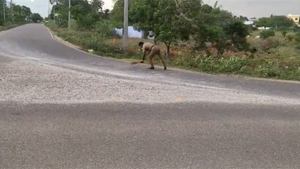 head Constable Jagadeesh sweeping Gravel scattered on road near Panakudi in Nellai head Constable Jagadeesh sweeping Gravel scattered on road near Panakudi in Nellai