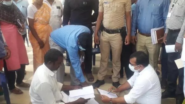 தரையில் உட்கார்ந்த கலெக்டர்