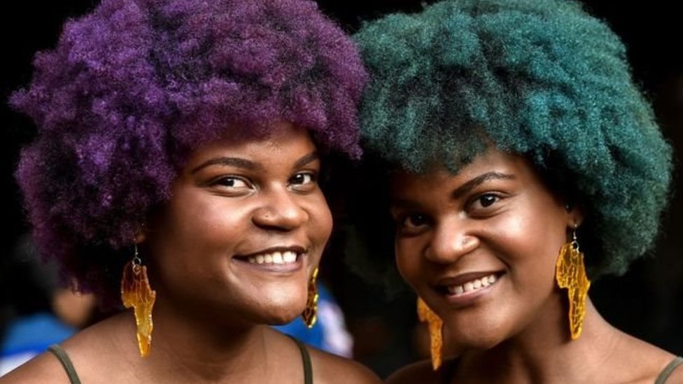 வண்ணமடித்த தலைமுடியோடு இரு பெண்கள்