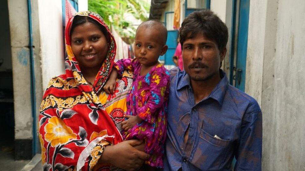 Picture of young pneumonia survivor and her parents outside home Picture of young pneumonia survivor and her parents outside home