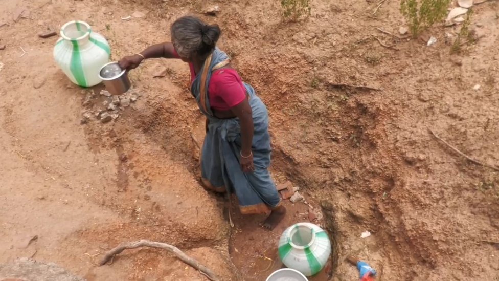 குழிக்குள் இருந்து தண்ணீர் எடுக்கும் மூதாட்டி குழிக்குள் இருந்து தண்ணீர் எடுக்கும் மூதாட்டி